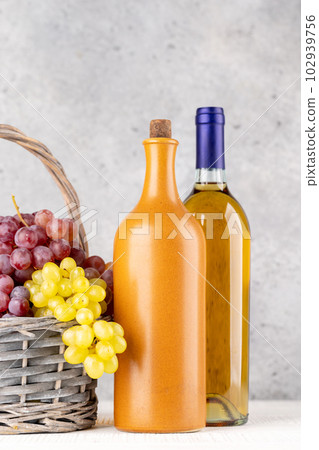 Ripe grape in basket and wine bottles Ripe grape in basket and wine bottles 102939756