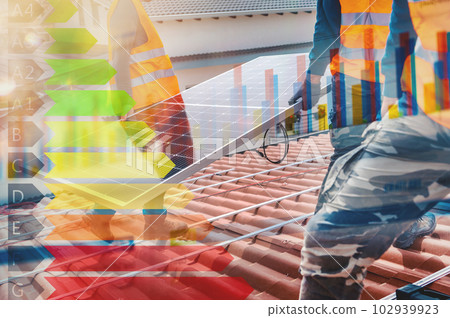 Workers assemble energy system with solar panel for electricity and hot water 102939923