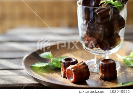 Mini canelés in stemware with mint leaves Mini canelés in stemware with mint leaves 102940925