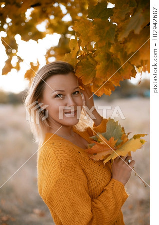 Woman holding autumn leafs in the nature. Autumn woman on leafs background Woman holding autumn leafs in the nature. Autumn woman on leafs background 102942687