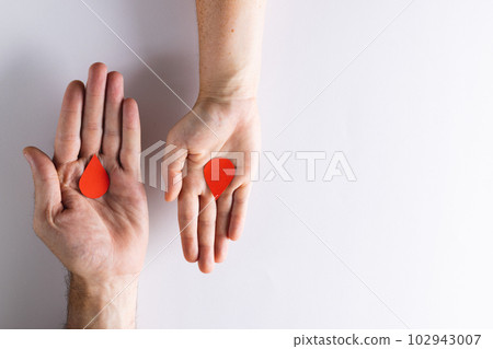 Hands of caucasian woman and man holding blood drops, on white background with copy space Hands of caucasian woman and man holding blood drops, on white background with copy space 102943007