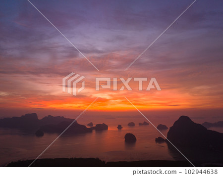 aerial view Amazing light of nature cloudscape sky above Samed Nang Chee Phang Nga archipelago. .Imagine a fantasy bright red sky at sunrise from a bird's eye view..tropical landscape background. aerial view Amazing light of nature cloudscape sky above Samed Nang Chee Phang Nga archipelago. .Imagine a fantasy bright red sky at sunrise from a bird's eye view..tropical landscape background. 102944638