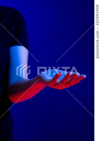 Exposed hand in studio with blue light with copy space 102945409