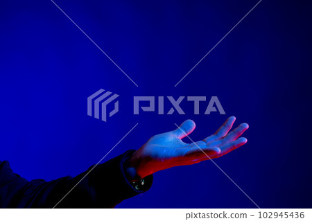 Exposed hand in studio with blue light with copy space 102945436