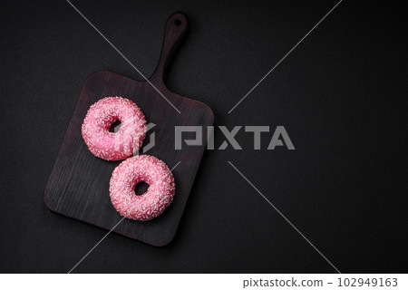 Delicious fresh sweet donuts in pink glaze with strawberry filling 102949163