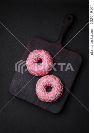 Delicious fresh sweet donuts in pink glaze with strawberry filling 102949164