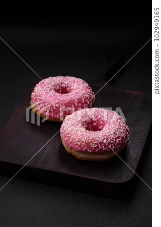 Delicious fresh sweet donuts in pink glaze with strawberry filling 102949165