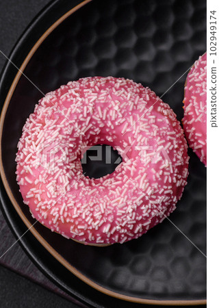 Delicious fresh sweet donuts in pink glaze with strawberry filling Delicious fresh sweet donuts in pink glaze with strawberry filling 102949174