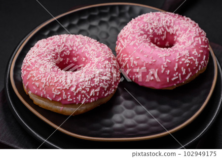 Delicious fresh sweet donuts in pink glaze with strawberry filling Delicious fresh sweet donuts in pink glaze with strawberry filling 102949175