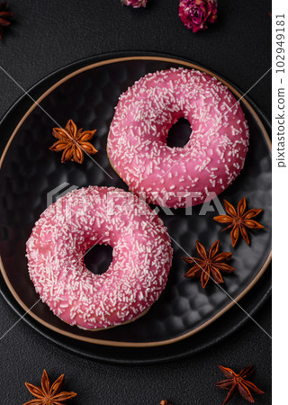 Delicious fresh sweet donuts in pink glaze with strawberry filling Delicious fresh sweet donuts in pink glaze with strawberry filling 102949181