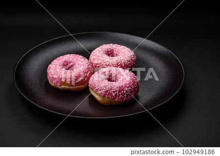 Delicious fresh sweet donuts in pink glaze with strawberry filling 102949186