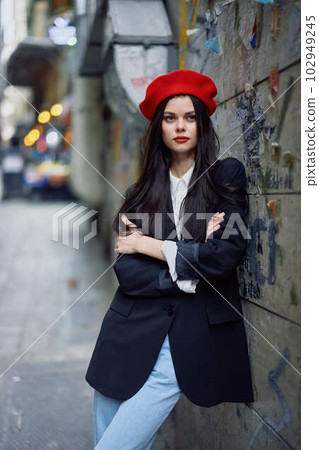 Fashion woman portrait walking tourist in stylish clothes with red lips walking down a narrow city street, travel, cinematic color, retro vintage style, dramatic against a wall with graffiti. Fashion woman portrait walking tourist in stylish clothes with red lips walking down a narrow city street, travel, cinematic color, retro vintage style, dramatic against a wall with graffiti. 102949245