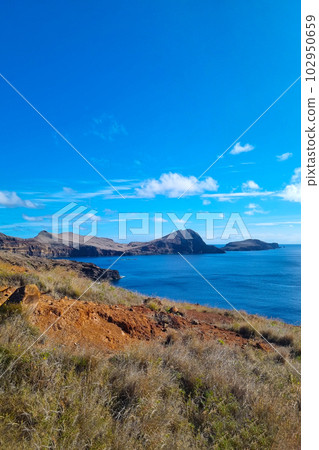 The rocky coast of the island of Madeira in the ocean. Beautiful tourist island. The rocky coast of the island of Madeira in the ocean. Beautiful tourist island. 102950659