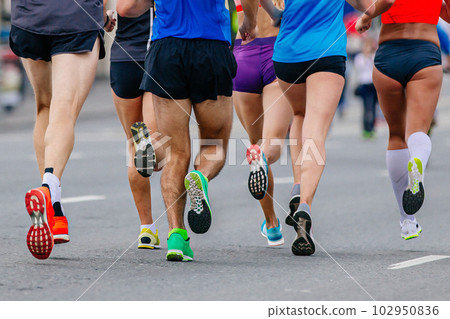 legs mixed group runners athletes running marathon in road, male and female joggers summer sports race 102950836