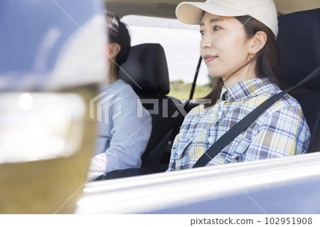 A woman sitting in the passenger seat in a drive 102951908