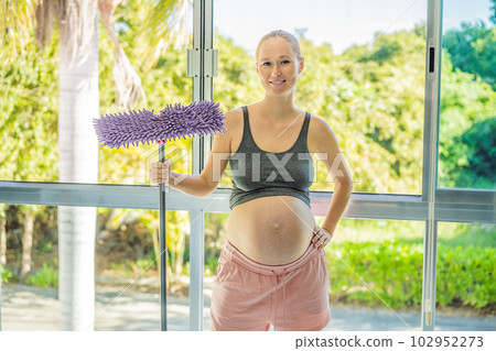 Pregnant woman washes the floor and is tired. Tired pregnant woman having pain in back while she is cleaning her house Pregnant woman washes the floor and is tired. Tired pregnant woman having pain in back while she is cleaning her house 102952273