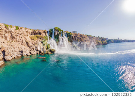 Lower Duden Falls drop off a rocky cliff falling from about 40 m into the Mediterranean Sea in amazing water clouds. Tourism and travel destination photo in Antalya, Turkey. Turkiye. Lower Duden Falls drop off a rocky cliff falling from about 40 m into the Mediterranean Sea in amazing water clouds. Tourism and travel destination photo in Antalya, Turkey. Turkiye. 102952325