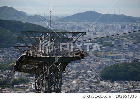 從俯瞰大海的山上看到的一組建築物前的索道鋼塔 102954339