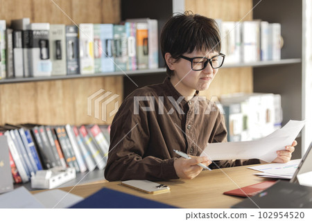 A young business woman who is worried about creating materials A young business woman who is worried about creating materials 102954520