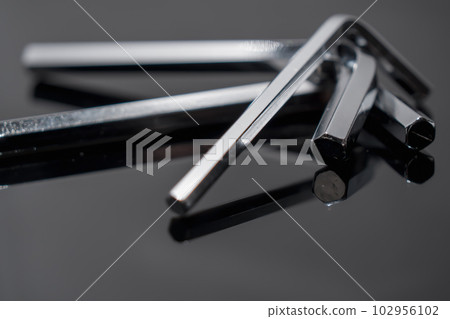 A hex wrench on a dark gray board 102956102