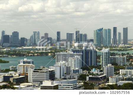 Aerial view of downtown office district of Miami in Florida, USA on bright sunny day. High commercial and residential skyscraper buildings in modern american megapolis Aerial view of downtown office district of Miami in Florida, USA on bright sunny day. High commercial and residential skyscraper buildings in modern american megapolis 102957556
