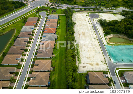 Aerial view of construction site with new tightly packed homes in Florida closed living clubs. Family houses as example of real estate development in american suburbs Aerial view of construction site with new tightly packed homes in Florida closed living clubs. Family houses as example of real estate development in american suburbs 102957579