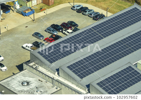 Aerial view of blue photovoltaic solar panels mounted on industrial building roof for producing green ecological electricity. Production of sustainable energy concept Aerial view of blue photovoltaic solar panels mounted on industrial building roof for producing green ecological electricity. Production of sustainable energy concept 102957602
