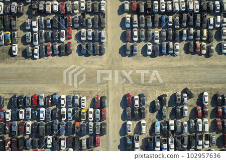 Aerial view of auction reseller company big parking lot with parked cars ready for remarketing services. Sales of secondhand vehicles Aerial view of auction reseller company big parking lot with parked cars ready for remarketing services. Sales of secondhand vehicles 102957636