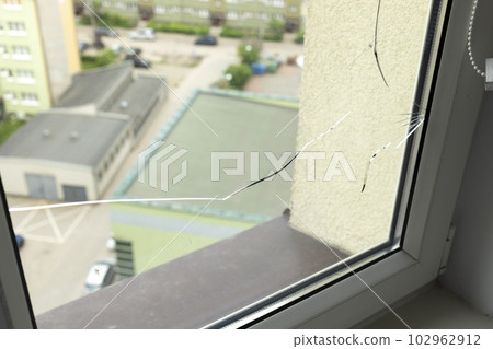 Crack, Broken Glass In A Double-glazed Window Due To Manufacturing Defect In Building, Home. Manufacturer's Defect, Defective Products. Horizontal Plane. Closeup. Crack, Broken Glass In A Double-glazed Window Due To Manufacturing Defect In Building, Home. Manufacturer's Defect, Defective Products. Horizontal Plane. Closeup. 102962912