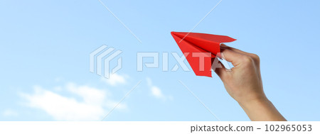 Female hand with paper plane on sky background Female hand with paper plane on sky background 102965053