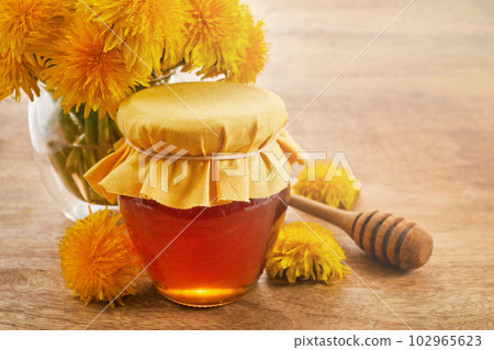 Honey or jam of dandelions in the jar with fresh flowers 102965623