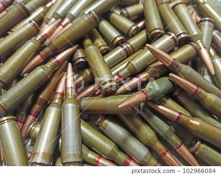 Cartridges for Kalashnikov assault rifle. War Concept. Heap of billets Cartridges for Kalashnikov assault rifle. War Concept. Heap of billets 102966084