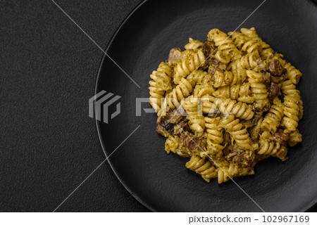 Delicious fusilli pasta with green pesto sauce, with salt and spices 102967169