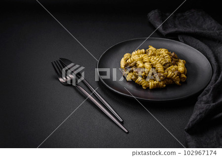 Delicious fusilli pasta with green pesto sauce, with salt and spices Delicious fusilli pasta with green pesto sauce, with salt and spices 102967174