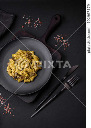 Delicious fusilli pasta with green pesto sauce, with salt and spices Delicious fusilli pasta with green pesto sauce, with salt and spices 102967179