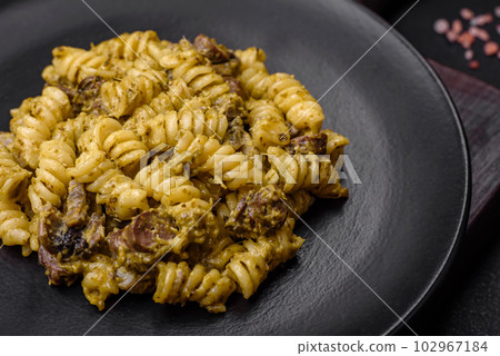 Delicious fusilli pasta with green pesto sauce, with salt and spices 102967184