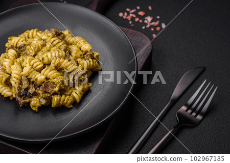 Delicious fusilli pasta with green pesto sauce, with salt and spices 102967185