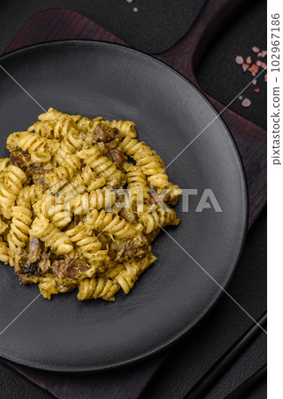 Delicious fusilli pasta with green pesto sauce, with salt and spices Delicious fusilli pasta with green pesto sauce, with salt and spices 102967186