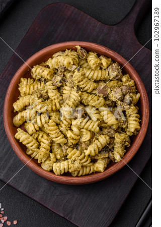 Delicious fusilli pasta with green pesto sauce, with salt and spices 102967189