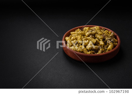 Delicious fusilli pasta with green pesto sauce, with salt and spices Delicious fusilli pasta with green pesto sauce, with salt and spices 102967198