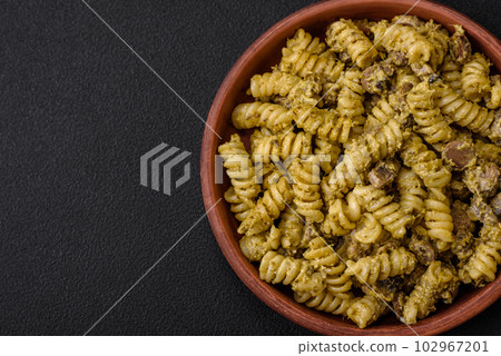 Delicious fusilli pasta with green pesto sauce, with salt and spices 102967201