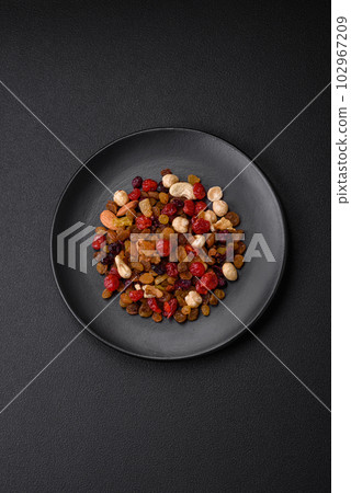 Mix of roasted cashews, hazelnuts and walnuts with dried cranberries and raisins Mix of roasted cashews, hazelnuts and walnuts with dried cranberries and raisins 102967209