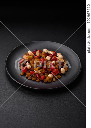 Mix of roasted cashews, hazelnuts and walnuts with dried cranberries and raisins Mix of roasted cashews, hazelnuts and walnuts with dried cranberries and raisins 102967210
