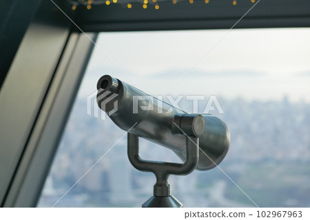 Coin-operated binoculars looking out over city , 102967963