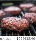 Delicious hamburger patty on grill 102968340