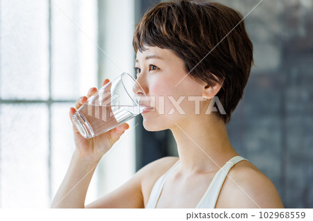 一個女人拿著一杯水 102968559