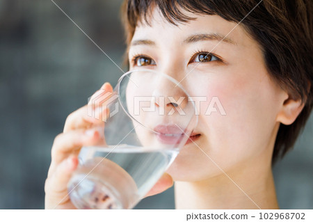 Young woman drinking water 102968702