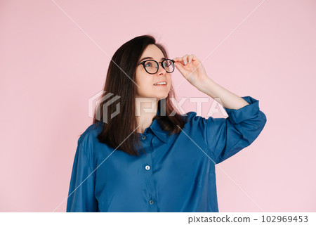 Thoughtful Woman in Glasses, Touching Her Frames, Deep in Contemplation, Searching for Ideas in 102969453