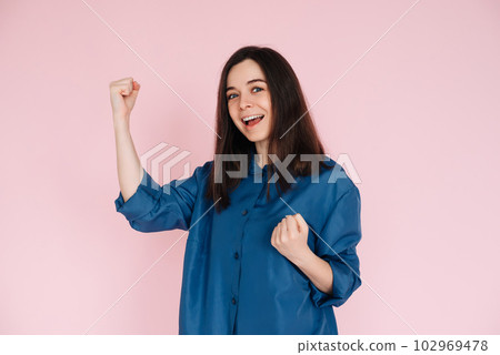 Triumphant Celebration: Photo of an Ecstatic Lady Raising Fists in Joyful Achievement, Embracing 102969478