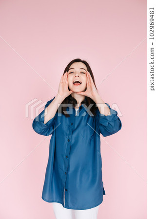 Expressive Joy: Close-Up Portrait of a Cheerful Young Woman's Hands near Open Mouth, Conveying Expressive Joy: Close-Up Portrait of a Cheerful Young Woman's Hands near Open Mouth, Conveying 102969481